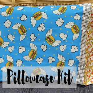May include: A pillowcase kit featuring a blue fabric with a pattern of flying hamburgers and white clouds. The other side of the pillowcase is a yellow fabric with a pattern of red and yellow french fries. The text "Pillowcase Kit" is printed in black on the front of the pillowcase.