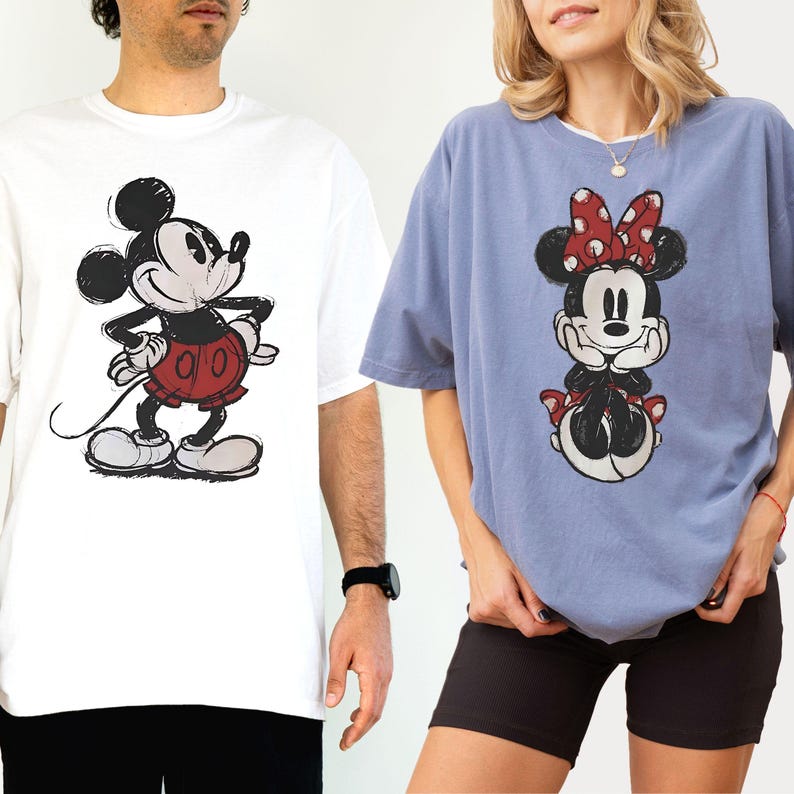 Puede incluir: Dos camisetas con Mickey y Minnie Mouse. La camiseta blanca tiene un gr&aacute;fico de Mickey Mouse negro y rojo. La camiseta azul tiene un gr&aacute;fico de Minnie Mouse con un lazo rojo. Ambas camisetas son de manga corta.