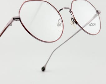 May include: A pair of eyeglasses with a burgundy-colored frame and clear lenses. The glasses have a modern, minimalist design with thin temples and the word "WOOW" printed on one lens.