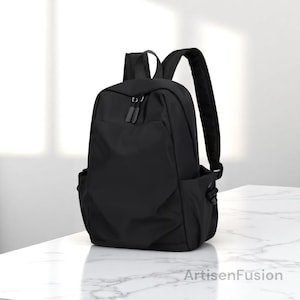 Petit sac à dos en toile noire pour homme - Sac à bandoulière de voyage étanche, sac à dos élégant pour l'école et le travail, sac de sport minimaliste pour homme