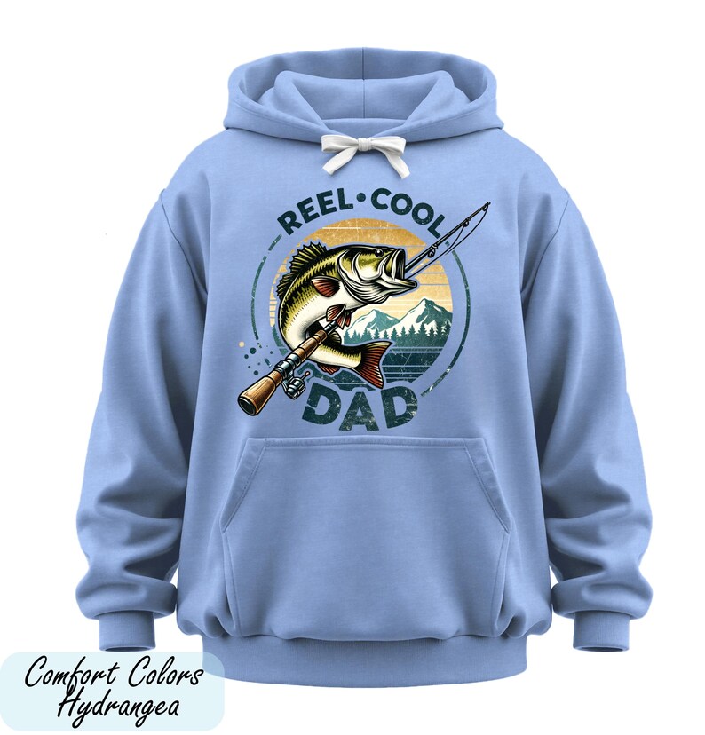 A blue hoodie with a graphic design featuring a fish and the text "REEL. COOL. DAD" printed on it.