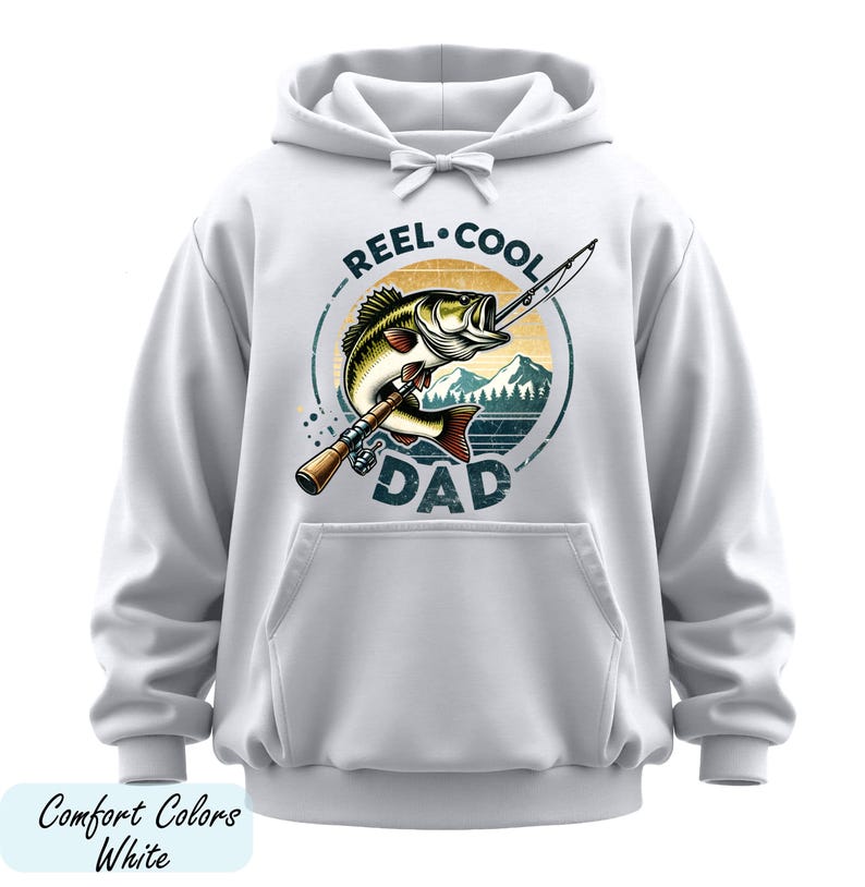 A white hoodie with a graphic design featuring a fish and the text "REEL. COOL. DAD" printed on it.