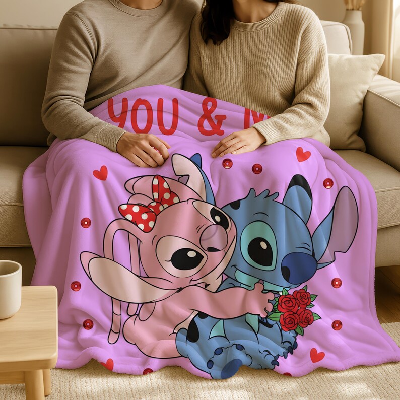 A couple sitting on a couch, wrapped in a blanket featuring the characters from the Disney movie Lilo & Stitch.