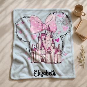 A personalized blanket featuring a cartoon illustration of a castle with a pink bow and hearts, along with the name "Eliza" written on it.