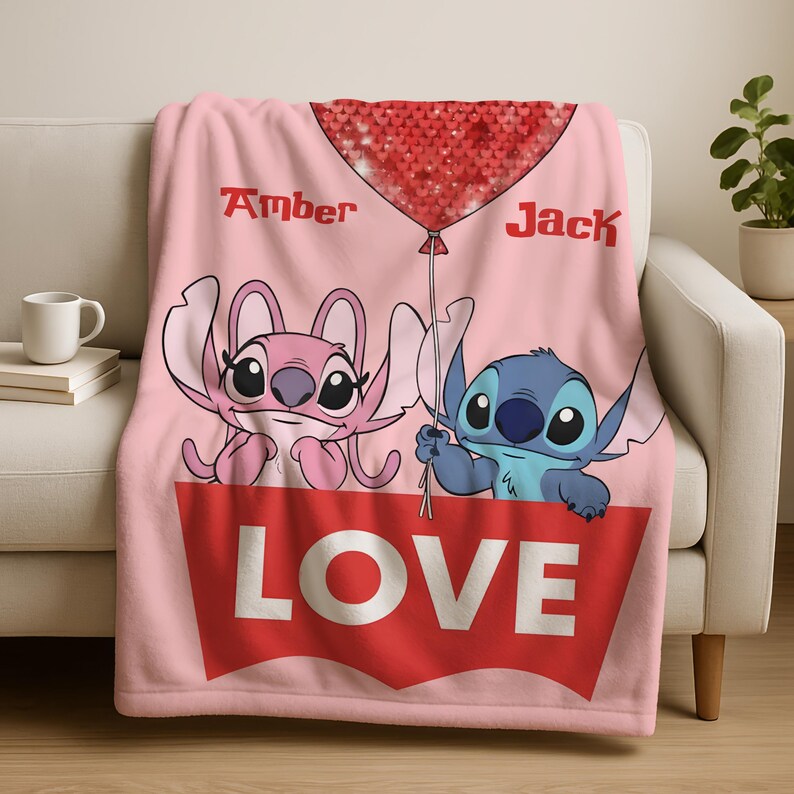 A pink blanket with a cartoon character design and the word "LOVE" written on it.