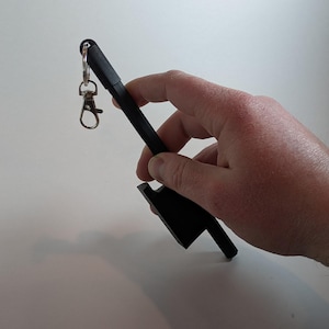 May include: A black keychain with a small axe design and a silver key ring.