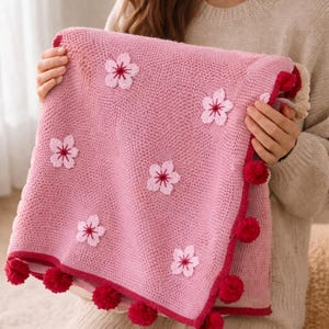 Puede incluir: Una taza de cerámica blanca con asa negra y el texto "But First, Coffee" en negrita negra. La taza se encuentra sobre un fondo borroso, sugiriendo un ambiente acogedor.