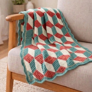 Puede incluir: Una manta de ganchillo hecha a mano con un patrón geométrico en rojo, turquesa y crema. La manta está sobre un sillón de madera. Los bordes de la manta tienen un borde festoneado turquesa, agregando un toque decorativo.