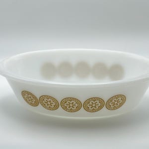 May include: White oval serving bowl with a gold floral design around the rim. The bowl has a simple, elegant design, perfect for serving dishes. The bowl is made of a durable material and is suitable for everyday use.