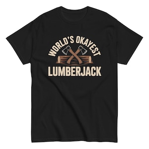 May include: Black t-shirt with a graphic design. The design features the text "WORLD'S OKAYEST LUMBERJACK" in a white, bold font. Two crossed axes are above the word "LUMBERJACK" and are set on top of a log.