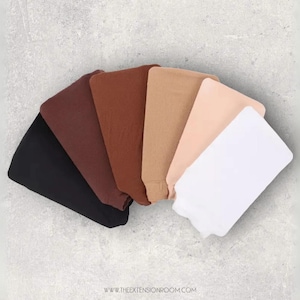 May include: A collection of six hair extensions in various shades, including black, brown, and blonde. The extensions are arranged in a fan shape, showcasing the range of colors available. The image is taken on a light gray background.