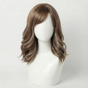 May include: A brown wig with wavy, shoulder-length hair and side-swept bangs. The wig is displayed on a white mannequin head. The hair has highlights of lighter brown and blonde.