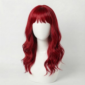 Puede incluir: Una peluca roja vibrante con cabello largo y ondulado y flequillo recto. La peluca se exhibe en una cabeza de maniquí blanca, mostrando su color y estilo. El cabello tiene una textura natural y un acabado brillante.