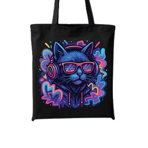 May include: Black tote bag featuring a vibrant illustration of a cat wearing headphones and sunglasses. The cat is surrounded by colorful, abstract shapes in shades of blue, pink, and purple. The bag has two black handles.