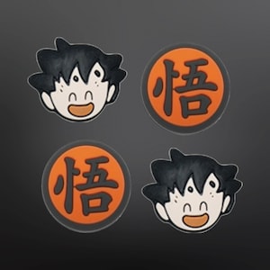 May include: Four orange and black round stickers with a cartoon character and the Japanese character for "love" on them.