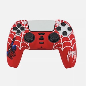 May include: A red and white PlayStation 5 controller with a Spiderman web design. The controller has a black and white Spiderman character on the left side and a white spider on the right side.