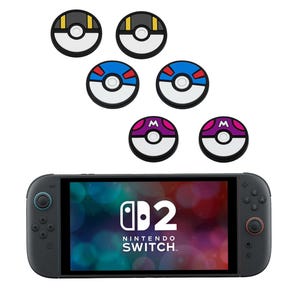 May include: A Nintendo Switch console with six colourful joystick caps. The caps feature designs in black, yellow, blue, red, white, and purple. The console screen displays the text "d2 Nintendo Switch."