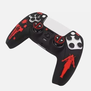 May include: Black and red PlayStation 5 controller with a Deadpool design. It features red accents, including the Deadpool logo on the thumbsticks and a Deadpool silhouette. The controller has white and black buttons.