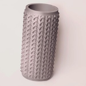 May include: A gray ceramic vase with a textured, woven pattern. The vase is cylindrical in shape and has a smooth, rounded top.