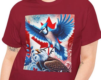 May include: A red t-shirt with a graphic of a blue jay and a bald eagle fighting over a Canadian flag. The graphic is in the center of the shirt.