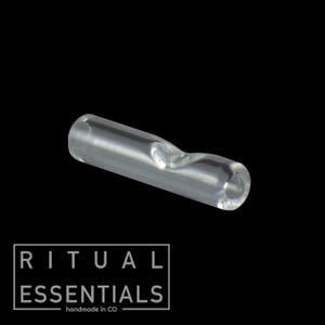 May include: A clear glass smoking accessory with a curved design. The product is cylindrical with a flared end and a curved indentation. The text "RITUAL ESSENTIALS handmade in CO" is printed in a white rectangular box.