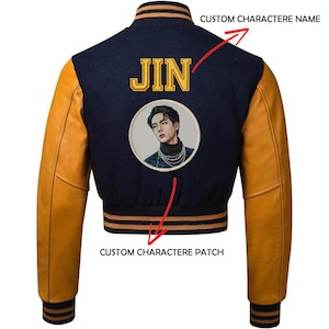 Peut inclure: Veste universitaire avec corps bleu marine et manches jaune moutarde. Le dos présente le nom "JIN" en lettres dorées au-dessus d'un écusson circulaire avec un portrait. La veste a des poignets et un col rayés.