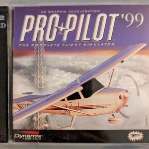 May include: A Pro-Pilot '99 flight simulator PC game in a clear plastic jewel case. The cover art features a light-colored single-engine airplane flying above clouds with a tall radio tower in the background. The text reads 3D Graphic Acceleration.