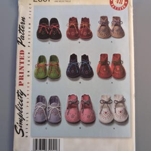May include: A Simplicity sewing pattern envelope for baby moccasins, numbered 2867. The front displays nine pairs of shoes in various colors including black, red, tan, green, blue, orange, purple, pink, and white, each featuring lace-up ties.