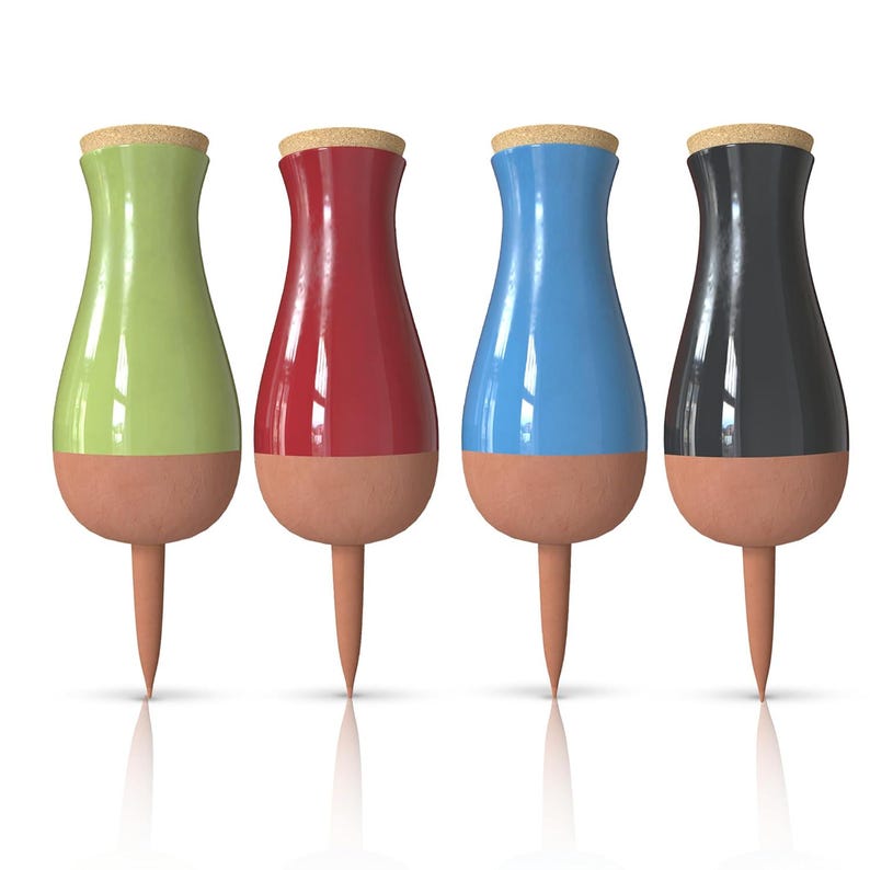 May include: Four ceramic watering spikes in different colors: green, red, blue, and black. Each spike has a pointed tip and a bulbous top with a cork stopper.