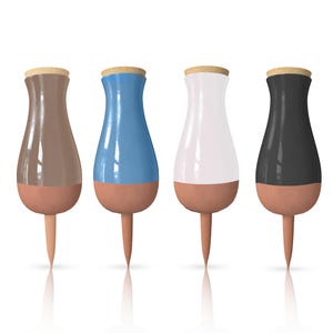 May include: Four decorative bottle stoppers in brown, blue, white, and black. Each stopper has a cork top, a colored glass body, and a terracotta-colored base and spike. The stoppers are arranged in a row against a white background.
