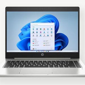 Peut inclure: Un ordinateur portable argenté avec un clavier noir et un design abstrait bleu et blanc à l'écran. L'écran affiche un menu de démarrage avec différentes icônes.