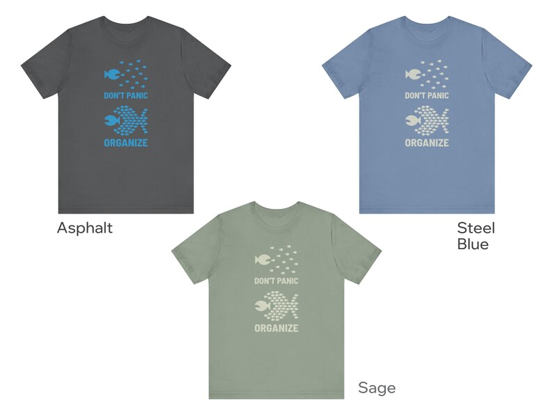 May include: Three t-shirts in asphalt, steel blue, and sage green. Each shirt features a fish graphic with the words "DON'T PANIC ORGANIZE". The shirts are short-sleeved and made of a soft material.