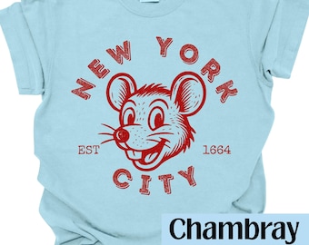 May include: Light blue t-shirt with a red graphic of a smiling mouse and the words "NEW YORK CITY" in a distressed font. The text "EST 1664" is also included. The shirt is made of a soft material and has a relaxed fit.