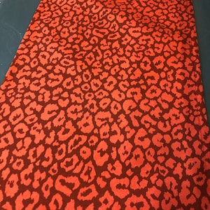 May include: Red fabric with a leopard print pattern.