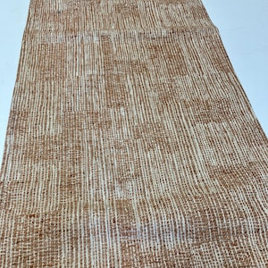 May include: A rectangular brown and cream-colored rug with a textured, woven pattern. The rug features vertical stripes of brown and cream, creating a natural, rustic aesthetic. Ideal for a hallway or entryway.