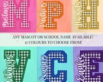 May include: Six short-sleeved t-shirts in pink, terracotta, butter, island reef, chalky mint, and violet. Each shirt features a large letter with a gingham pattern and a school mascot name written in white script text across the letter.