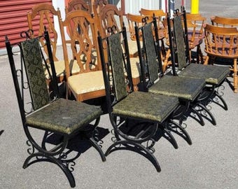 vintage 1960s wrought iron dining chairs feature a black metal frame with scrollwork details and upholstered seats.