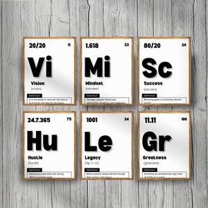 Puede incluir: Seis impresiones enmarcadas con palabras motivadoras al estilo de una tabla periódica. Las palabras incluyen Visión, Mentalidad, Éxito, Esfuerzo, Legado y Grandeza. Cada impresión tiene un fondo blanco con texto negro y un marco de madera.