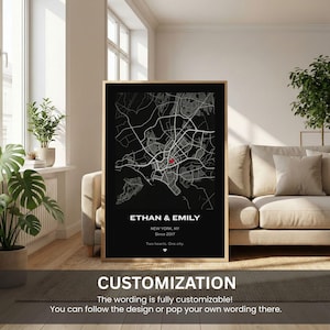 May include: A framed black and white map print with a red dot marking a location. The text "ETHAN & EMILY" is at the top, with "NEW YORK, NY Since 2017" below. The bottom reads "Two hearts. One city." The text "CUSTOMIZATION" is at the bottom.