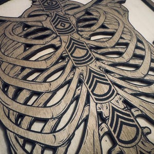 May include: Wooden wall art depicting a rib cage with black outlines and a light brown wood grain. The text "KBONE OF THE ARMY" is at the top. The design incorporates military insignia.