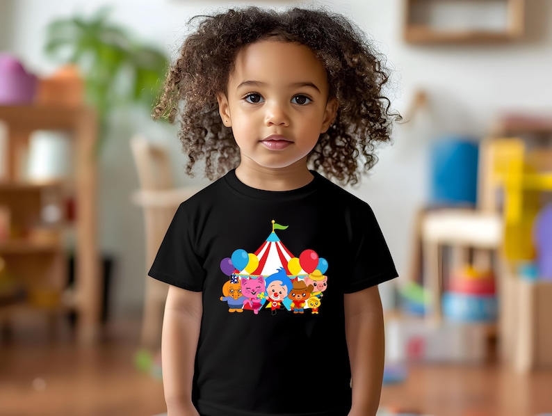 a little girl with curly hair wearing a t - shirt with cartoon characters on it