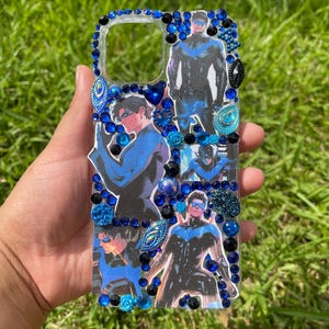 Könnte beinhalten: Transparente Handyhülle mit Bildern eines Superhelden in einem blau-schwarzen Kostüm. Die Hülle ist mit blauen und schwarzen Strasssteinen und Edelsteinen an den Rändern verziert.