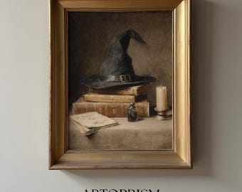May include: A framed painting depicts a still life with a black witch's hat atop stacked books. A lit candle, inkwell, and parchment add to the mystical theme. The artwork is framed in a gold-colored ornate frame. The text "ARTOPRISM art that inspires" is at the bottom.