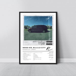 Puede incluir: Un póster enmarcado con la portada del álbum "Good Kid, M.A.A.D City" de Kendrick Lamar. La obra de arte muestra una furgoneta oscura en una calle bajo un cielo azul. El póster incluye el título del álbum, el nombre del artista y la lista de canciones.
