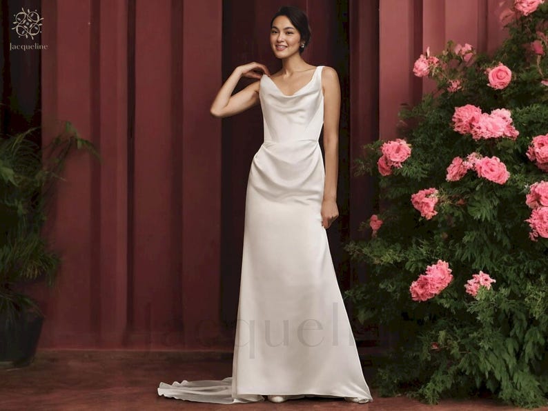 May include: A white satin cowl neck wedding dress with a fitted bodice and a flowing skirt.