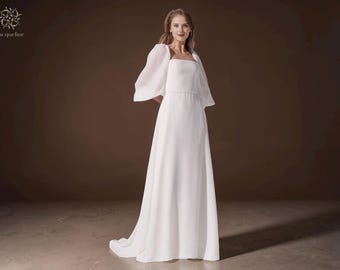 Elegante vestido de novia de gasa, escote cuadrado y mangas abullonadas, estilo minimalista.