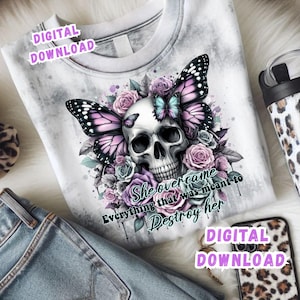 May include: White graphic t-shirt featuring a skull with butterfly wings and floral accents in shades of purple, pink, and blue. The text "She overcame everything that was meant to destroy her" is also visible.