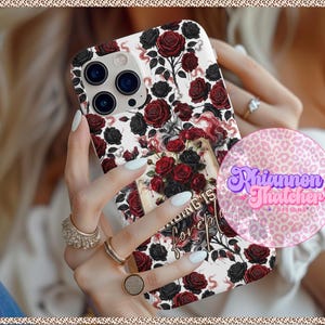 May include: A white phone case with a floral design of red and black roses. The case has a rectangular shape and features a camera cutout. The words "Nothing is forever" are visible on the case. A pink and purple logo is also visible.
