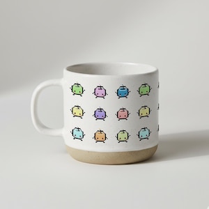 Könnte beinhalten: Eine weiße Keramiktasse mit beigem Boden und weißem Henkel. Die Tasse ist mit einem sich wiederholenden Muster aus pixeligen, farbenfrohen, cartoonartigen Figuren verziert. Die Figuren sind in verschiedenen Farben gehalten, darunter Grün, Lila und Blau.