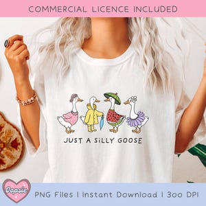 May include: A white t-shirt with a graphic of five geese wearing different outfits. The geese are lined up in a row and the text "Just a silly goose" is printed below them.